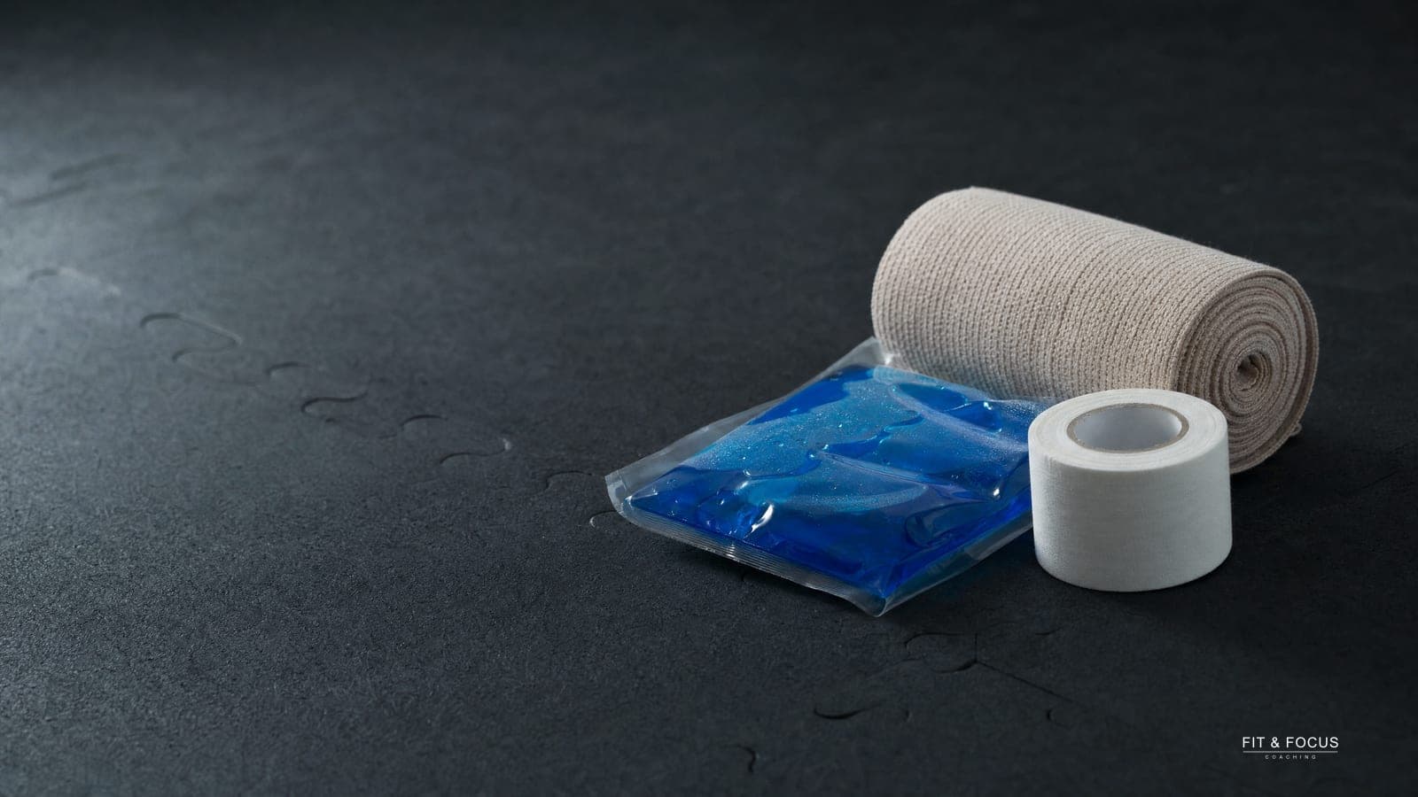 Opgerold elastisch verband, een blauwe koelpack en witte sporttape