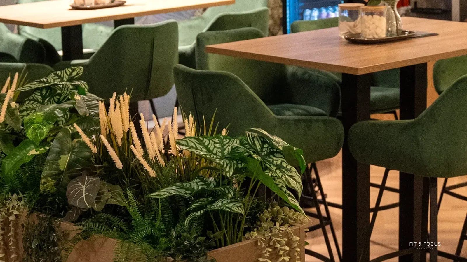 Groene stoelen rond een houten statafel in de zithoek