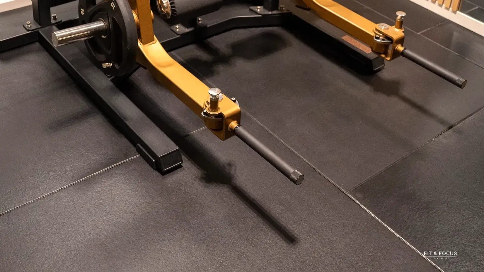 Detail van het goudkleurige frame van een krachttoestel
