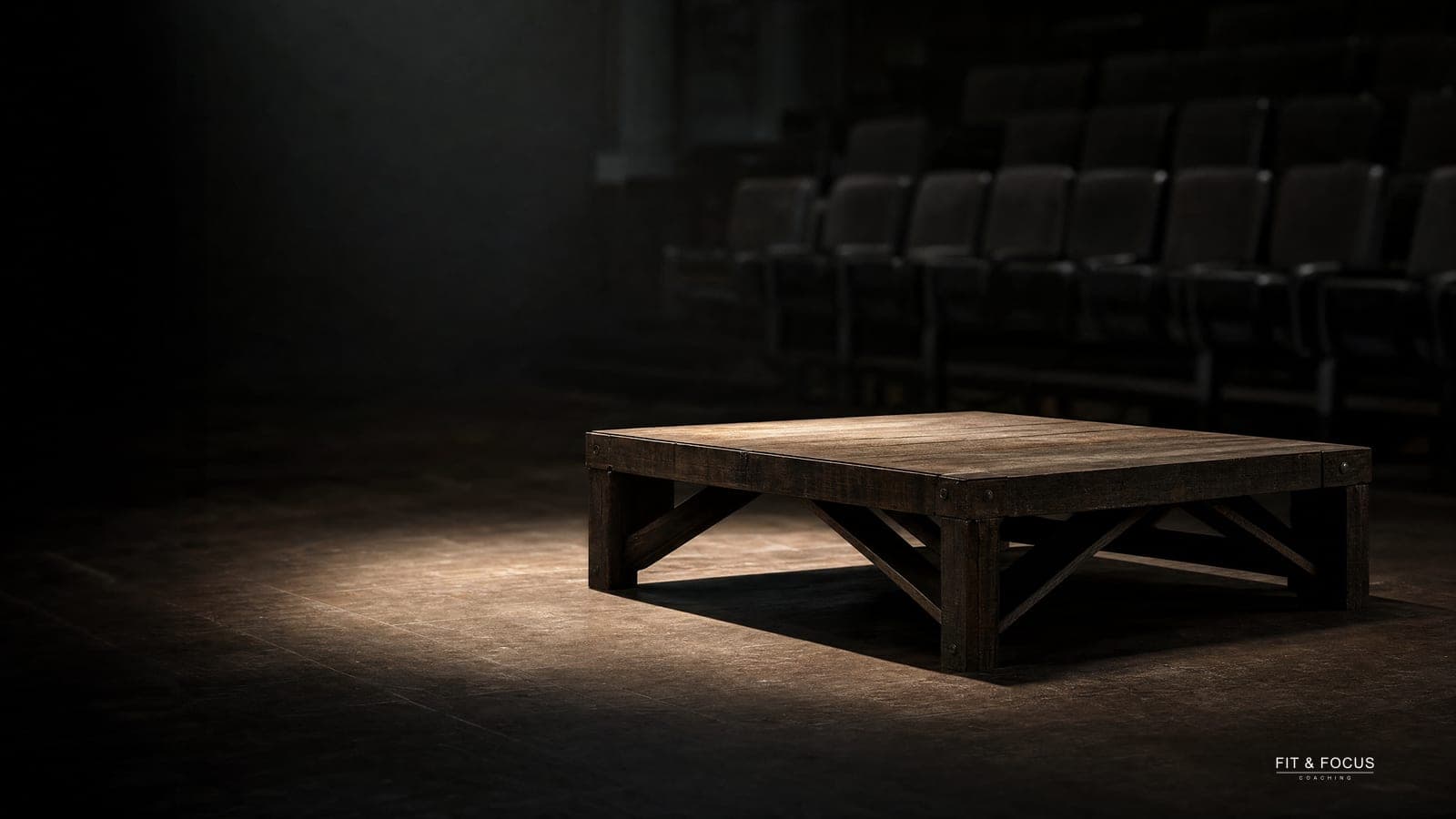 Leeg podium in een donkere zaal, uitgelicht door een enkele spot