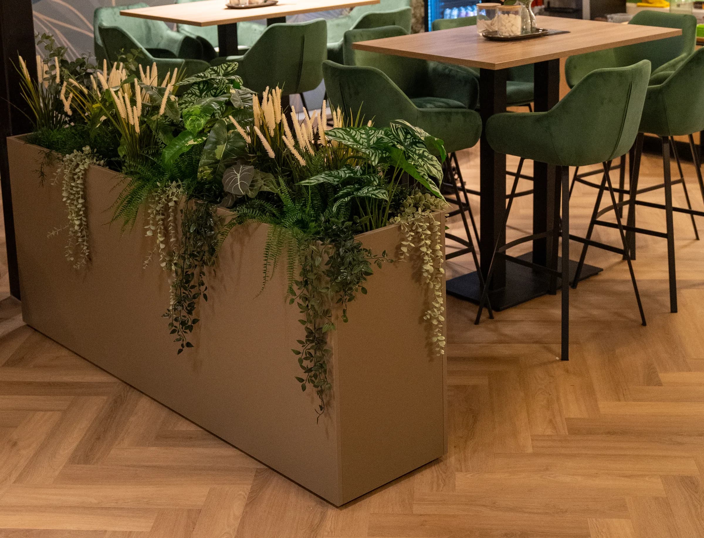 Koffiehoek met groene fauteuils en planten