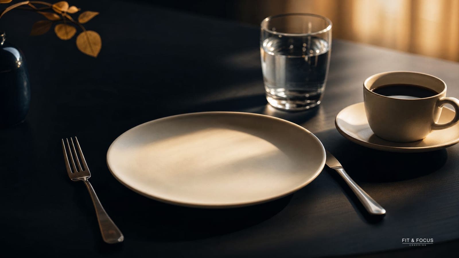 Leeg bord met bestek, een glas water en een kop zwarte koffie op een donkere tafel