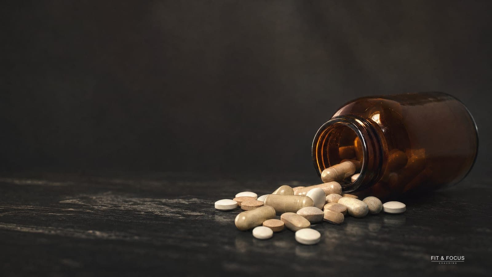 Omgevallen bruin glazen potje met capsules en tabletten ernaast